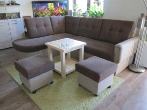 Modernes Wohnzimmer-Ecksofa mit Hockern und Aquarium.