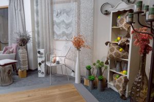 Ecke mit stilvoller Dekoration, Pflanzen, Gardienen und natürlichem Licht