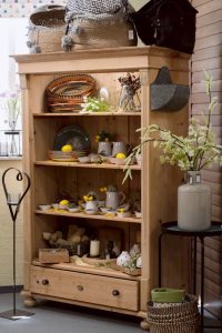 Holzregal mit Dekorationsartikeln, Geschirr und Wohnaccessoires in rustikalem Stil.