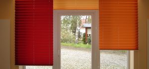 Fenster mit roten und orangefarbenen Jalousien in modernem Raum.