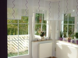 Flächenvorhänge im Wintergarten mit Blick auf Balkon und Natur