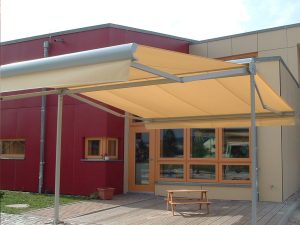 Markise über Kindergarten-Terrasse, wetterfest und langlebig, ideal für Sonnenschutz im Außenbereich.