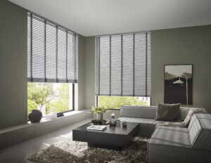 Modernes Wohnzimmer mit KADECO Filz-Jalousien JHM5 in Grau vor großen Fenstern mit Gartenblick